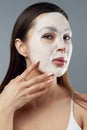 Beauty Facial Mask . Beautiful Woman with a cloth moisturizing mask on face .Skin care. Cosmetic spa mask Royalty Free Stock Photo