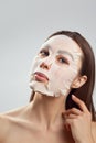 Beauty Facial Mask.  Woman with a cloth moisturizing mask on face .Skin care .Cosmetic  spa mask Royalty Free Stock Photo