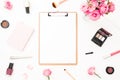 Beauty or fashion blog composition with pink roses bouquet, cosmetics, diary and clipboard on white background. Top view. Flat lay Royalty Free Stock Photo