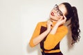 Beauty Fashion brunette model girl wearing stylish glasses. woman with perfect makeup, trendy orange and red dress Royalty Free Stock Photo