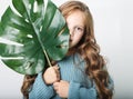 Beauty and fashion concept: Little curly girl child wearing blue sweater and holding flower Royalty Free Stock Photo