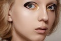 Beauty & fashion. Girl model face with bright holiday gold and black liner make-up, clean skin Royalty Free Stock Photo