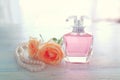Beauty/fashion Image of elegant perfume bottle, white pearls and delicate roses over pastel background. vintage filtered image
