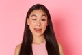 Beauty, fashion and lifestyle concept. Close-up of cute and silly, kawaii asian girl making funny faces, showing tongue Royalty Free Stock Photo