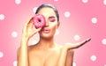 Beauty fashion model girl holding sweet pink colorful donut