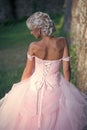 Beauty Fashion model girl. Fashion look. Girl pose in pink dress with open shoulders, back view Royalty Free Stock Photo