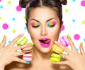 Beauty fashion model girl taking colorful macaroons Royalty Free Stock Photo