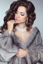 Beauty Fashion Model Woman in Mink Fur Coat. Winter Brunette Girl in Luxury clothes. Long wavy hair. Makeup. Jewelry. Royalty Free Stock Photo