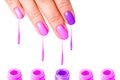 Beauty, fashion and Nail art concept. Woman hand close-up with five bottles of pink and purple gel nail polish and drops from fing Royalty Free Stock Photo