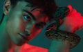 Beauty, fashion and portrait of man with snake in neon studio shoot with danger and creative art style. Skincare, color