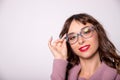 Beauty fashion girl wearing glasses showing empty copy space, white background. Happy girl presenting trendy Royalty Free Stock Photo