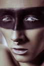 Beauty fashion shot of young man with nose rings and black strip line makeup and white eyelash. Male beauty portrait