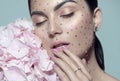 Beauty fashion Woman face decorated with gem stones, crystals. Closeup Portrait with Hydrangea. Model girl with holiday makeup