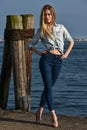 Beauty fashionable blondie woman standing on the pier. Royalty Free Stock Photo