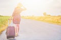 Woman hitchhiker with suitcase