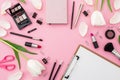 Beauty frame with clipboard, tulips, cosmetics and accessory on pink background. Top view. Flat lay Royalty Free Stock Photo