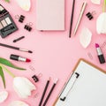 Beauty frame composition with clipboard, flowers, cosmetics and accessory on pink background. Top view. Flat lay Royalty Free Stock Photo