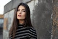 Beauty frontal portrait of a cheerful girl with straight brunette hair, dressed in modern clothes, with makeup.