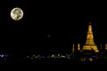 The beauty of the full Moon and Wat Arun at night with gold. Royalty Free Stock Photo