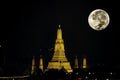 The beauty of the full Moon and Wat Arun at night with gold. Royalty Free Stock Photo