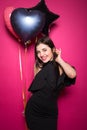 Beauty girl with colorful air balloons laughing, isolated on pink background. Beautiful Happy Young woman on birthday holiday Royalty Free Stock Photo