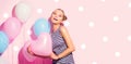 Beauty girl with colorful air balloons laughing over pink background. Beautiful Happy Young woman on birthday holiday party Royalty Free Stock Photo