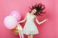 Beauty girl with colorful air balloons laughing over pink background. Beautiful Happy Young woman on birthday holiday party. Danci Royalty Free Stock Photo