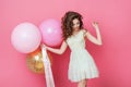 Beauty girl with colorful air balloons laughing over pink background. Beautiful Happy Young woman on birthday holiday party. Danci Royalty Free Stock Photo