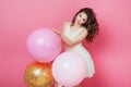 Beauty girl with colorful air balloons laughing over pink background. Beautiful Happy Young woman on birthday holiday party. Fashi Royalty Free Stock Photo