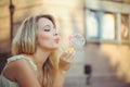 Beauty girl with colorful soap bubbles laughing. Beautiful happy young woman on a sunny bright day. Joyful model plays with soap Royalty Free Stock Photo