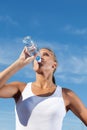 Beauty girl drink water from plastic bottle outdoors on a sky ba Royalty Free Stock Photo
