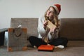 Beauty girl opening present gifts sitting on sofa at home Royalty Free Stock Photo