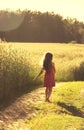 Beauty Girl Outdoors enjoying nature. Beautiful little girl in red dress running on the Spring Field. Toned Royalty Free Stock Photo