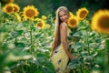 Beautiful Teenage Model girl with long healthy hair posing on the Sunflower Spring Field Royalty Free Stock Photo