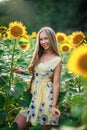 Beautiful Teenage Model girl with long healthy hair posing on the Sunflower Spring Field Royalty Free Stock Photo