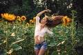 Beautiful Teenage Model girl with long healthy hair posing on the Sunflower Spring Field Royalty Free Stock Photo