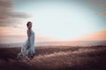 Beauty Girl Outdoors enjoying nature. Beautiful Teenage Model girl in white dress running on the Spring Field, Sun Light Royalty Free Stock Photo