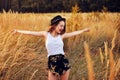 Beauty Girl Outdoors enjoying nature. Pretty Teenage Model in hat running on the Spring Field, Sun Light. Romantic Royalty Free Stock Photo