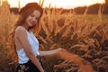 Beauty Girl Outdoors enjoying nature. Pretty Teenage Model in hat running on the Spring Field, Sun Light. Romantic Royalty Free Stock Photo