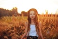 Beauty Girl Outdoors enjoying nature. Pretty Teenage Model in hat running on the Spring Field, Sun Light. Romantic Royalty Free Stock Photo