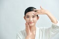 Beauty girl portrait. Young natural woman with clean face sitting at white table leaning on her elbows, over white background Royalty Free Stock Photo