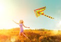 Beauty girl in short dress running with flying colorful kite Royalty Free Stock Photo