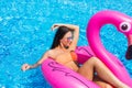 Beauty girl sits on inflatable mattress flamingos in the pool and have fun. Pool party Royalty Free Stock Photo