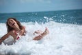 Beauty girl sits in sea surf Royalty Free Stock Photo