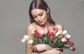 Beauty glamour girl with Spring tulips Flower bouquet. Beautiful young woman with a Bunch of colorful Tulip flowers