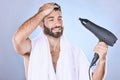 Beauty, hair care and man with blow dryer on blue background for cleaning, body wellness and salon. Luxury spa, shower Royalty Free Stock Photo