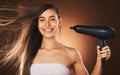 Beauty, hair and hairdryer with a model woman in studio on a brown background for blowdrying or treatment. Portrait