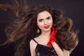 Beauty hair. Long shiny wavy hairstyle. Beautiful brunette portrait with red lips, fashion earring jewelry wearing in lace gloves Royalty Free Stock Photo