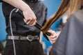 Beauty, hairstyle concept, happy young woman and hairdresser with hair iron making hairdo at hair salon. Woman Having Royalty Free Stock Photo