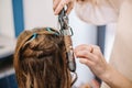beauty, hairstyle concept, happy young woman and hairdresser with hair iron making hairdo at hair salon. Woman Having Royalty Free Stock Photo
